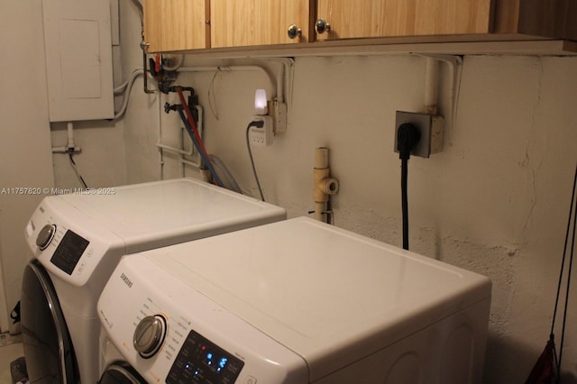 clothes washing area featuring separate washer and dryer, cabinet space, and electric panel