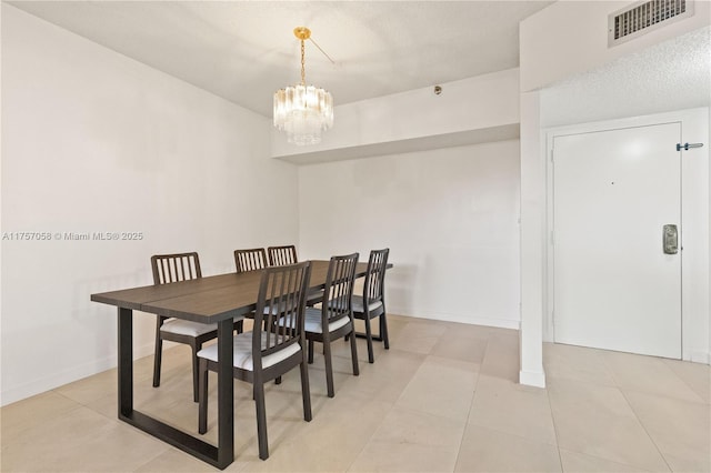 dining area featuring light tile patterned floors, baseboards, visible vents, and a notable chandelier