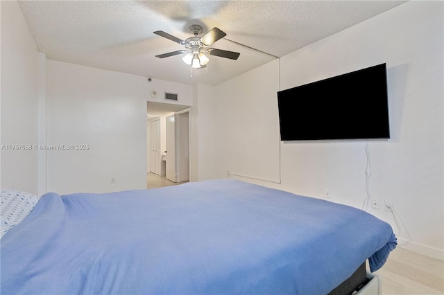 bedroom featuring a ceiling fan, visible vents, and a textured ceiling