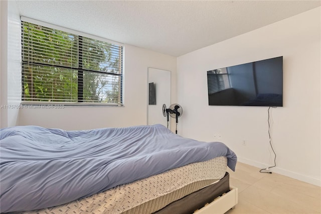 bedroom featuring a textured ceiling and baseboards