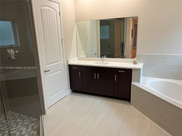 full bath featuring a garden tub, a shower stall, and vanity