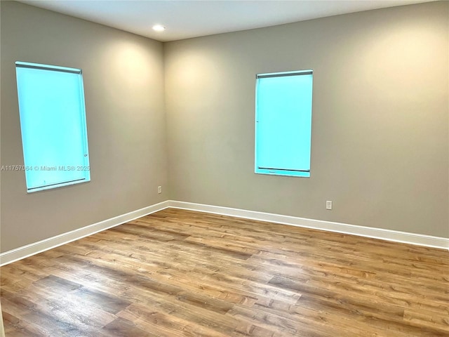 empty room featuring recessed lighting, baseboards, and wood finished floors