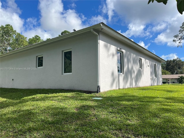 view of side of property featuring a yard and stucco siding