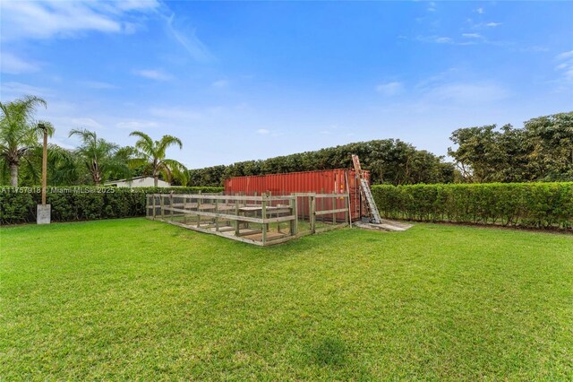 view of yard with fence and an outdoor structure