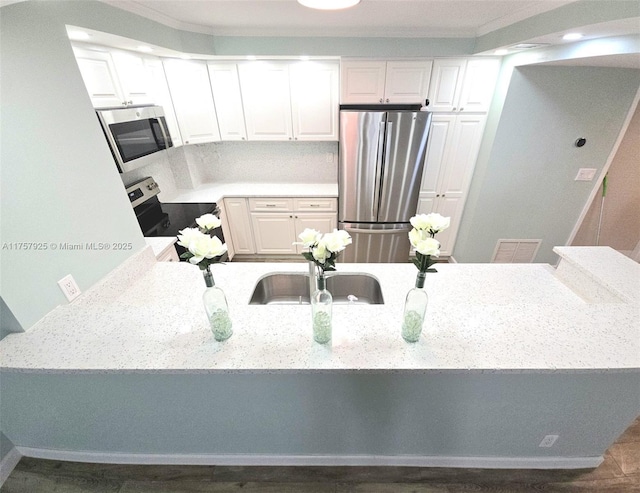 kitchen with stainless steel appliances, visible vents, ornamental molding, and light stone countertops