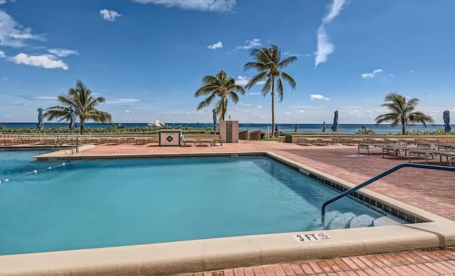 community pool featuring a water view and a patio