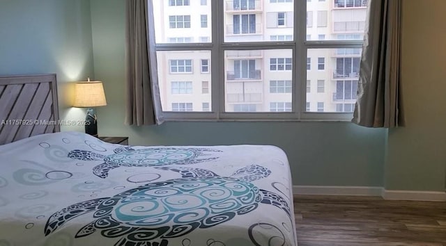 bedroom with baseboards and wood finished floors