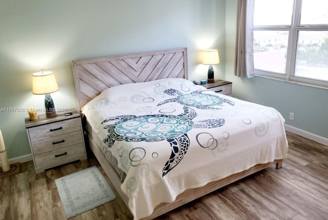 bedroom featuring wood finished floors and baseboards