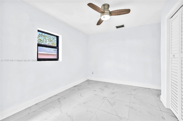 spare room featuring ceiling fan, marble finish floor, visible vents, and baseboards