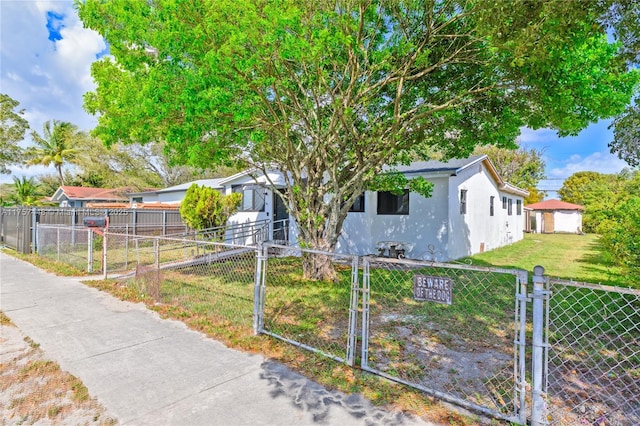 view of front facade with a fenced front yard, a gate, and stucco siding