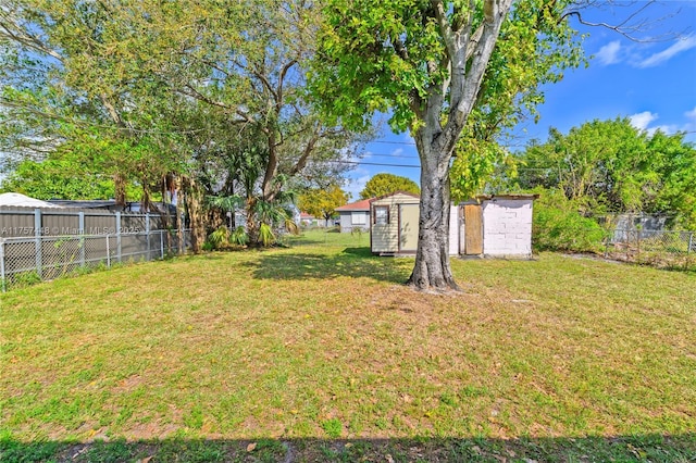 view of yard with a storage shed, an outdoor structure, and a fenced backyard