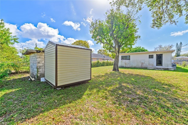 view of yard with an outbuilding, a storage shed, and fence