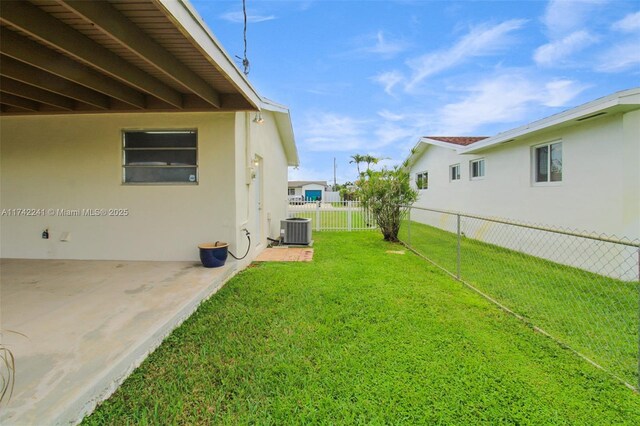 view of yard featuring a patio area, fence, and central air condition unit