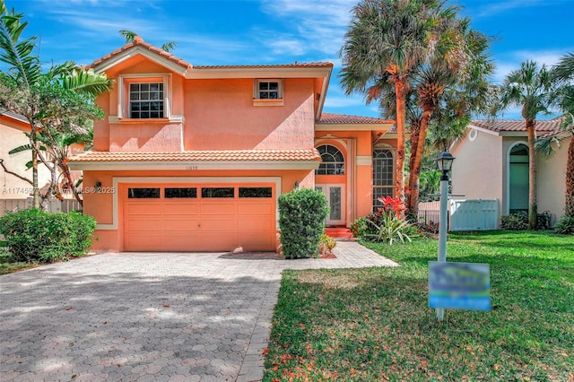 mediterranean / spanish-style house with a garage, a front yard, decorative driveway, and stucco siding