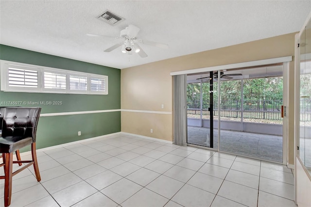 spare room featuring visible vents, ceiling fan, a textured ceiling, and light tile patterned floors