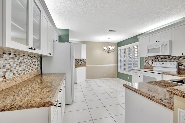 kitchen featuring light tile patterned floors, a chandelier, white appliances, glass insert cabinets, and pendant lighting