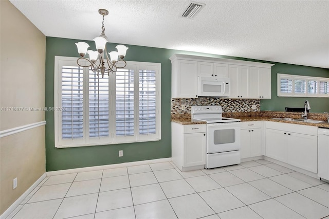 kitchen with white appliances, visible vents, white cabinets, and a sink