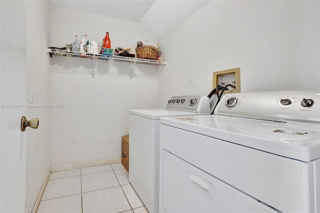 washroom featuring light tile patterned floors, laundry area, a textured ceiling, and independent washer and dryer