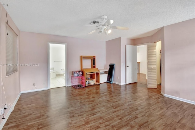 bedroom with a textured ceiling, wood finished floors, and visible vents