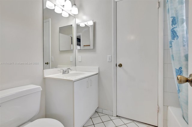 bathroom with toilet, vanity, and tile patterned floors