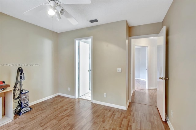 unfurnished bedroom with baseboards, visible vents, ceiling fan, and light wood finished floors