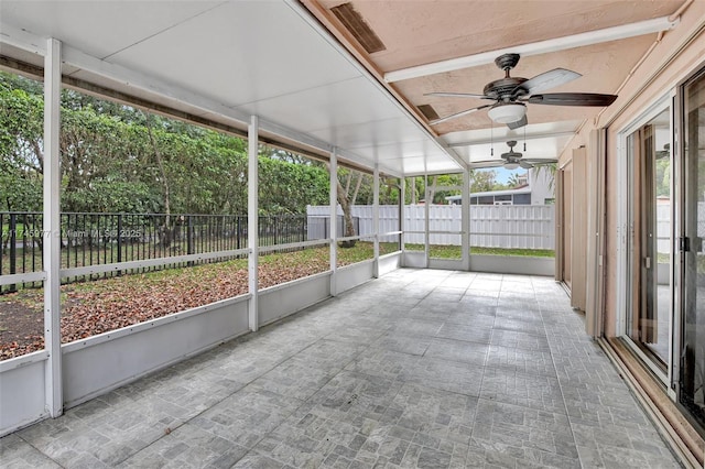 unfurnished sunroom with a ceiling fan