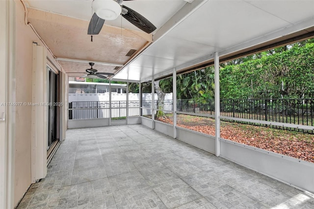 unfurnished sunroom featuring ceiling fan