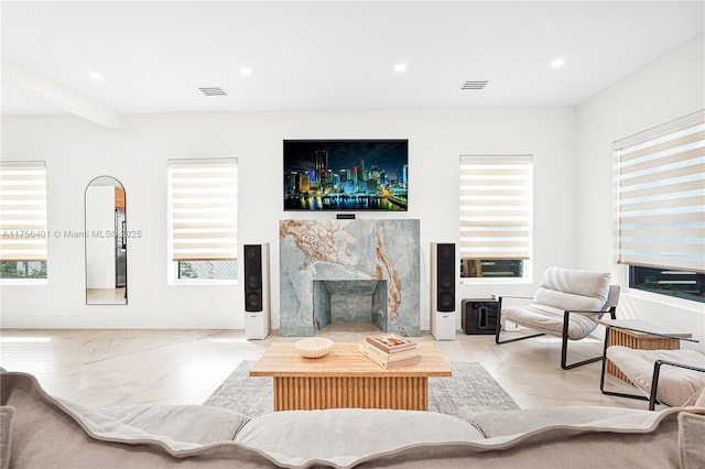 living area featuring recessed lighting, visible vents, and a premium fireplace