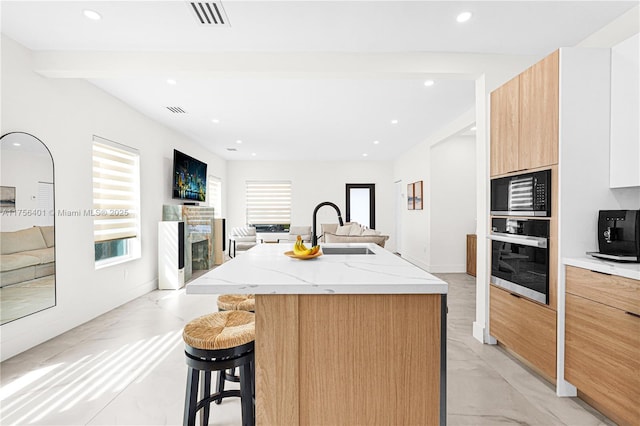 kitchen with open floor plan, oven, visible vents, and modern cabinets