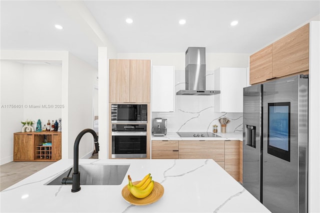 kitchen with a sink, appliances with stainless steel finishes, wall chimney range hood, backsplash, and modern cabinets