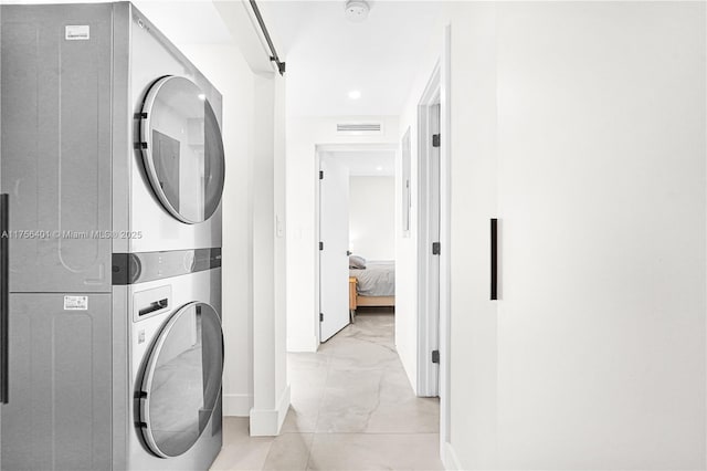 laundry room with laundry area, stacked washer / dryer, visible vents, baseboards, and marble finish floor