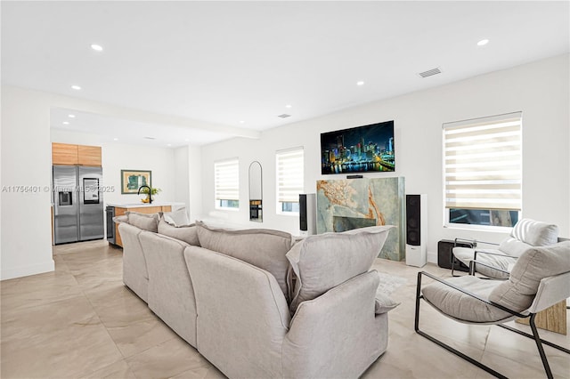 living area featuring baseboards, a fireplace, visible vents, and recessed lighting