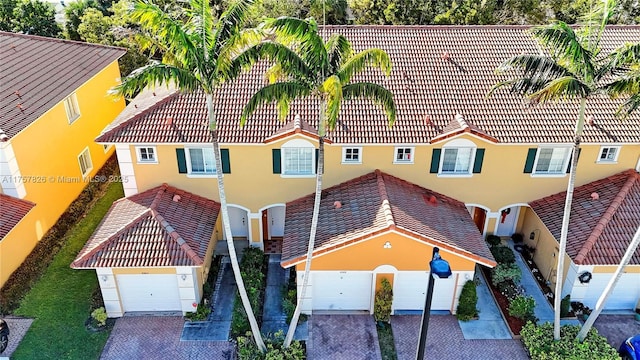 view of front of property with a garage, a tiled roof, and stucco siding