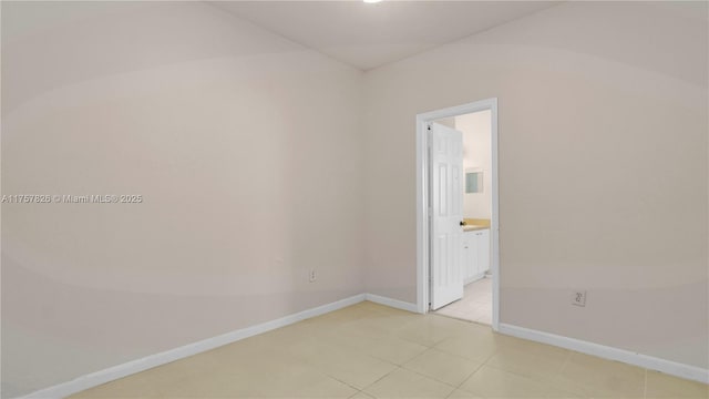 spare room with baseboards and light tile patterned floors