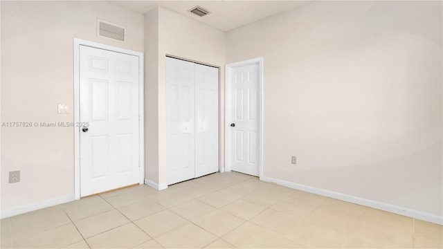 unfurnished bedroom with a closet, visible vents, and baseboards