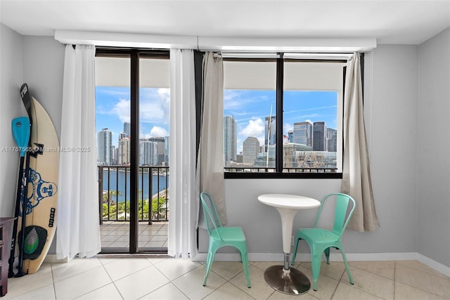 sitting room with baseboards, plenty of natural light, tile patterned flooring, and a city view