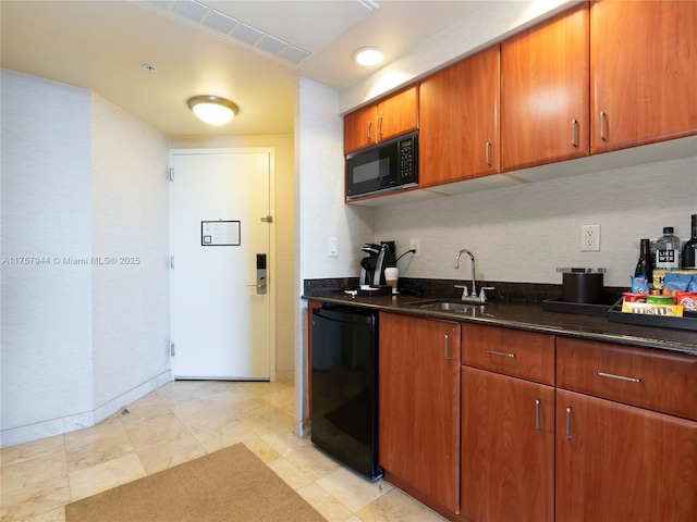 kitchen featuring a sink, visible vents, dark stone counters, black appliances, and brown cabinetry