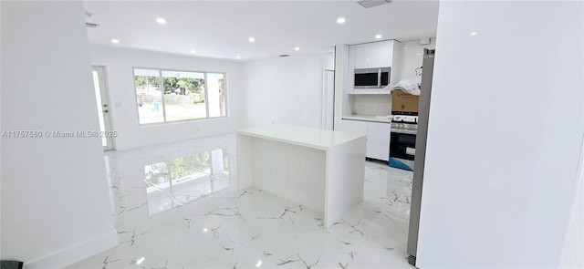 kitchen with recessed lighting, white cabinets, marble finish floor, appliances with stainless steel finishes, and modern cabinets