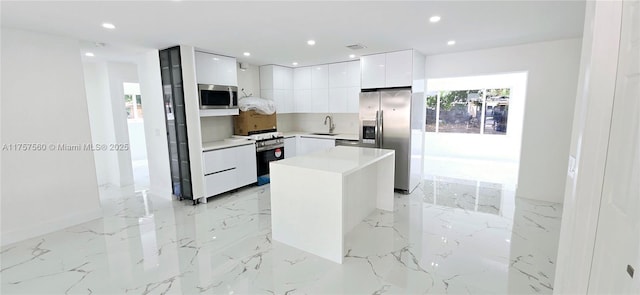 kitchen with recessed lighting, appliances with stainless steel finishes, white cabinets, a sink, and modern cabinets