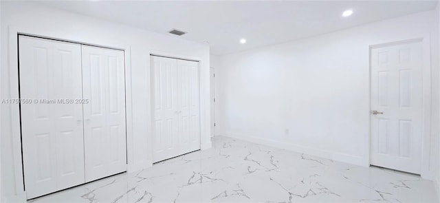 unfurnished bedroom featuring recessed lighting, visible vents, baseboards, multiple closets, and marble finish floor