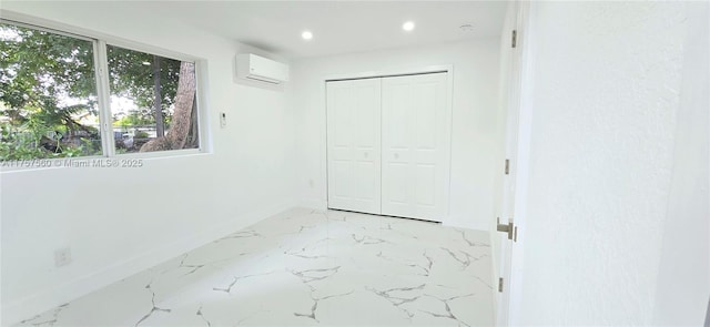 unfurnished bedroom with baseboards, a wall unit AC, marble finish floor, a closet, and recessed lighting