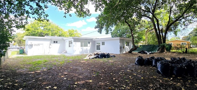 back of property with fence and stucco siding