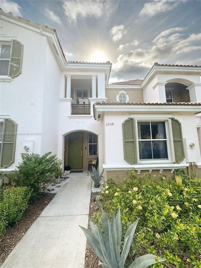 property entrance with a balcony and stucco siding