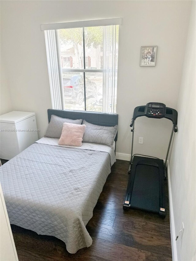 bedroom with baseboards and wood finished floors