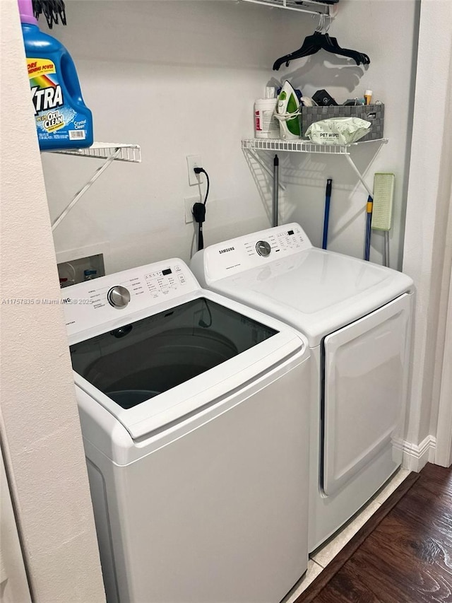 laundry room with laundry area, separate washer and dryer, and wood finished floors