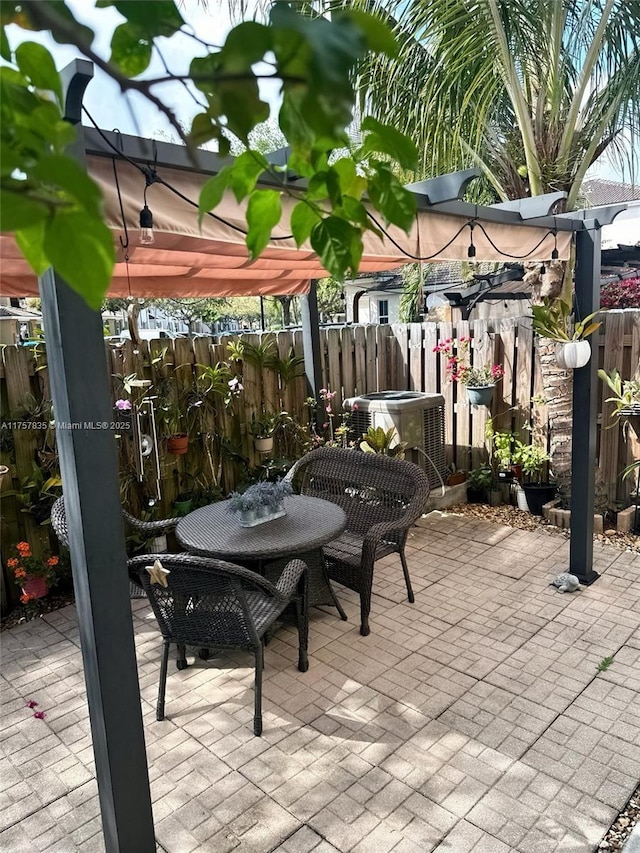 view of patio featuring a hot tub, fence, cooling unit, a pergola, and outdoor dining space