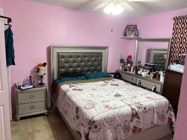 bedroom featuring a ceiling fan, light tile patterned flooring, and a textured ceiling