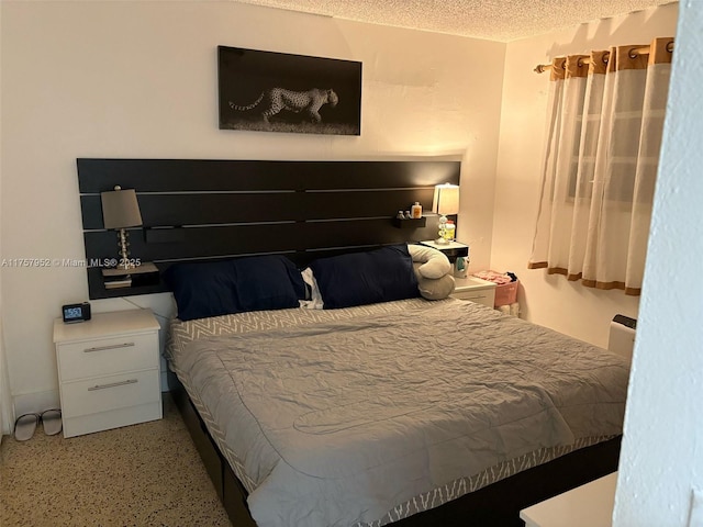 bedroom featuring a textured ceiling and speckled floor