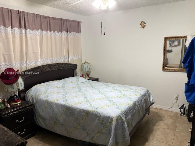 bedroom with light tile patterned floors, baseboards, and a textured ceiling