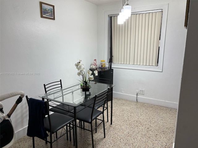 dining area featuring baseboards and speckled floor